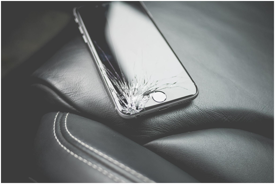 iPhone with smashed screen on a car seat