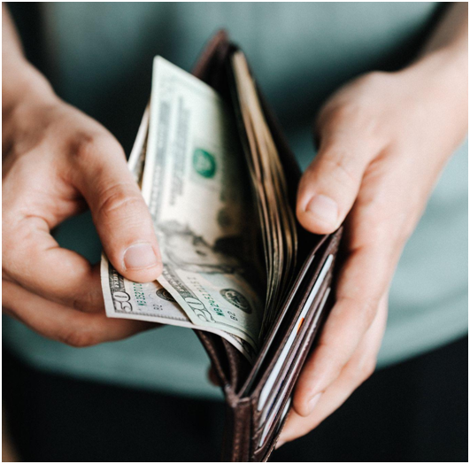 person pulling money out of wallet