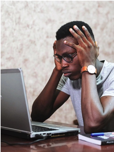 frustrated man looking at a laptop