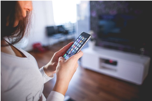 Woman holding an iPhone using it